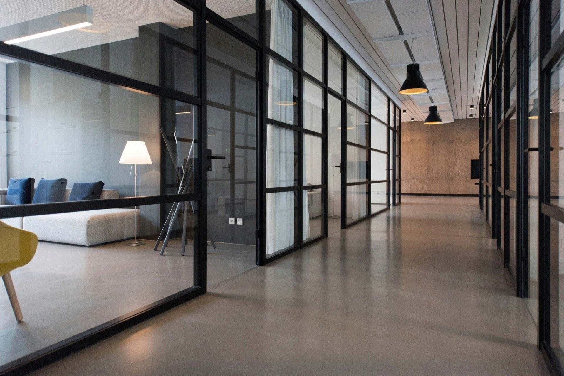 Modern office corridor with glass-walled meeting rooms